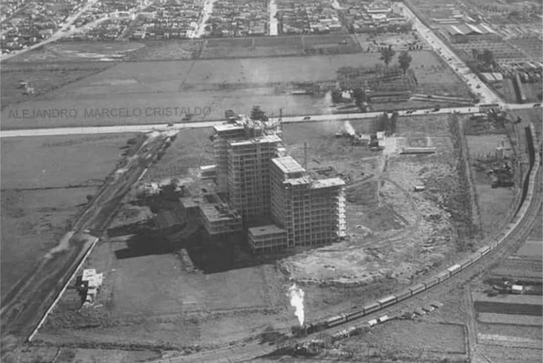 Vista aérea del hospital en construcción, rodeado de terrenos vacíos